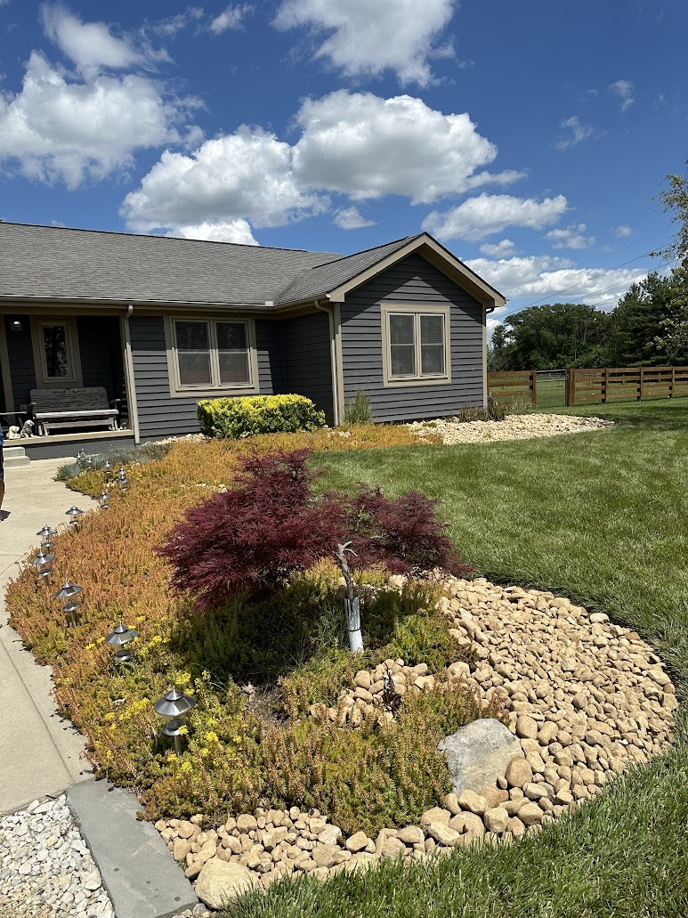 A house with a rock garden in front of it